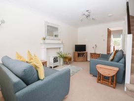 A living room with a sofa, television, and coffee table at 17 Fewster Way York