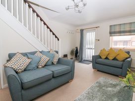 A living room with sofas and a staircase at 17 Fewster Way in York
