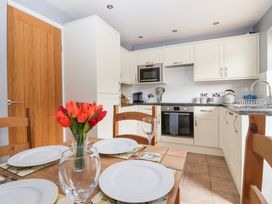 A kitchen with a dining table and flower vase at 17 Fewster Way in York