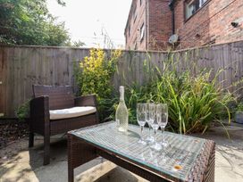 A garden with a chair, table, bottle and glasses at 17 Fewster Way in York