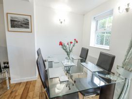 A dining room with a glass table and chairs at Preswylfa Apartment in Caernarfon