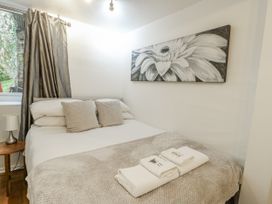 A bedroom with a bed and side table at Preswylfa Apartment, Caernarfon
