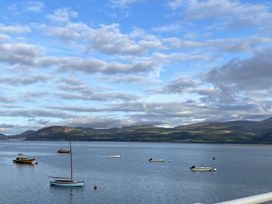 A coastal view with boats on water and hills in the background at Sant Seiriol in Beaumaris