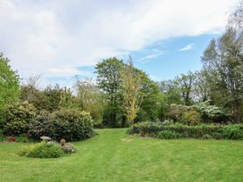A garden with grass and trees at Erin Cottage Pelynt near Looe