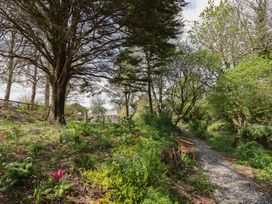 A garden with trees and a gravel path at Hook Cottage Pelynt near Looe