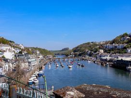 A view of boats on a river with buildings and a bridge at Hook Cottage in Pelynt near Looe