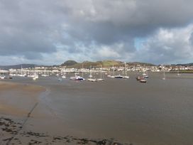 A coastal scene with boats on the water and a town in the background at Cymryd Uchaf in Conwy