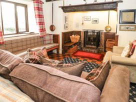 A living room with sofas a fireplace and plaid curtains at Cymryd Uchaf in Conwy