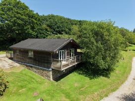 A house with a deck in a grassy area at 1 Lake View in Lanreath
