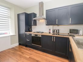 A kitchen with cabinets and appliances at Molly's Cottage in Flookburgh