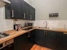 A kitchen with cabinets and appliances at Molly's Cottage in Flookburgh