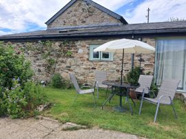 A garden with a table and chairs at Owl Barn in Tavistock