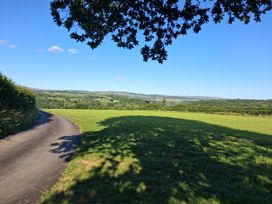 A pathway surrounded by grass and hills at Owl Barn in Tavistock