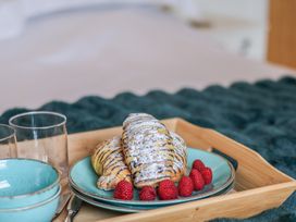 A tray with croissants and raspberries in a bedroom at 5 Old Sail Loft Whitby