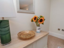 A table with a lamp and a vase of sunflowers at 5 Old Sail Loft in Whitby