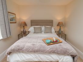 A bedroom with a bed and nightstands at 5 Old Sail Loft in Whitby
