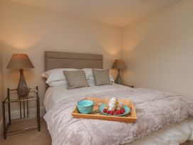 A bedroom with a bed and a tray of food at 5 Old Sail Loft in Whitby