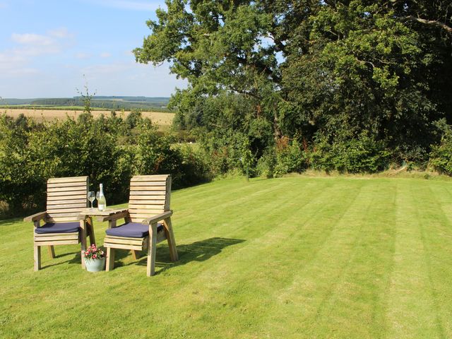 A garden with two chairs and a table at Birds Nest in Jedburgh