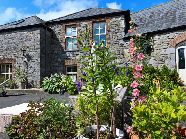 A stone building with plants and seating area at Coach House Kilbeg near Borris-In-Ossory County Laois