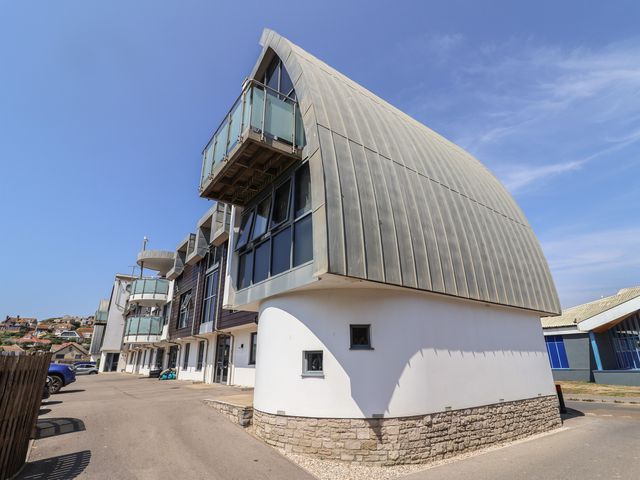 A building with balconies and windows at Harbourwalk in West Bay
