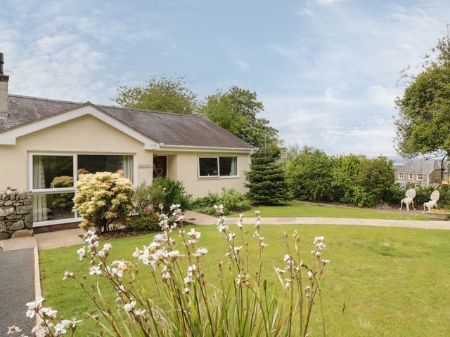 A single-story house with a garden and white flowers in front at Clyd Fan in Harlech