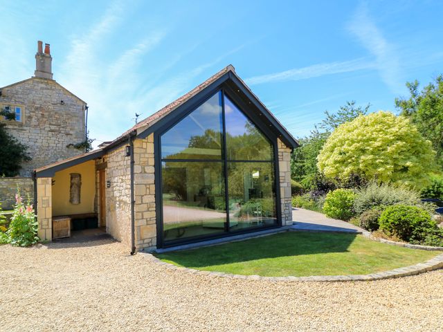 A building with large windows and a garden at Pheasant Cottage in Priston Village, BATH