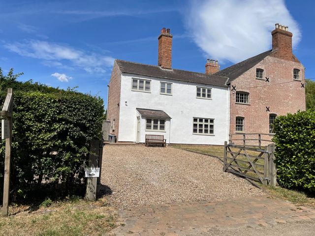 A house with a driveway and garden at Warren House Cottage in Wragby
