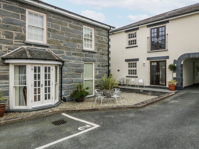 An outdoor area with a building and seating at Bwthyn Llechen in Porthmadog