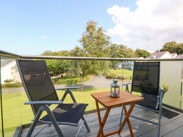 A balcony with two chairs and a table at Machlud Ynys, Y Felinheli