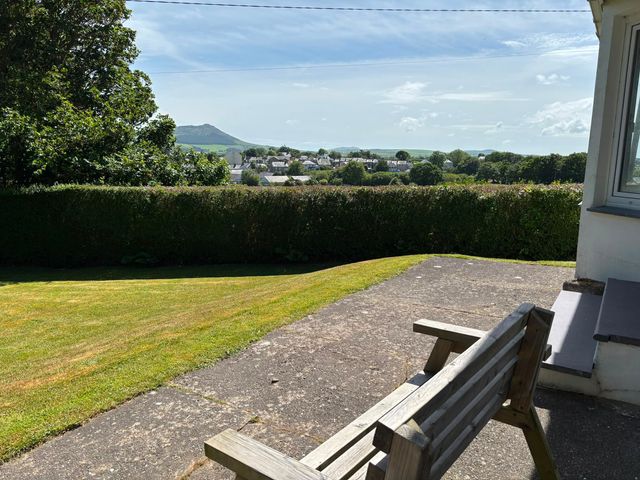 A garden with a bench and scenic view at Ty Bryn - Nefyn, Morfa Nefyn