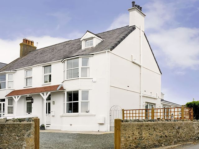 A house with a garden and fence at West View in Rhosneigr