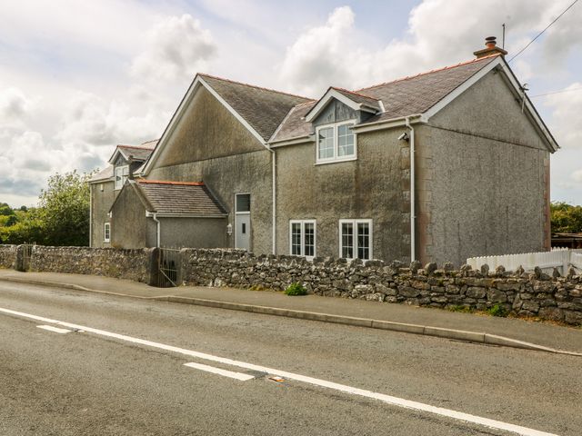A house with windows and a fence on the roadside at Llanallgo Church Rooms