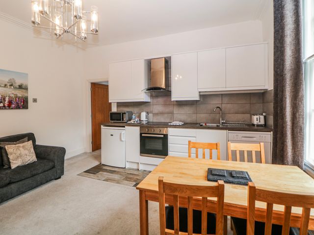 A kitchen with a dining table and sofa at Gulliver's (76) Matlock