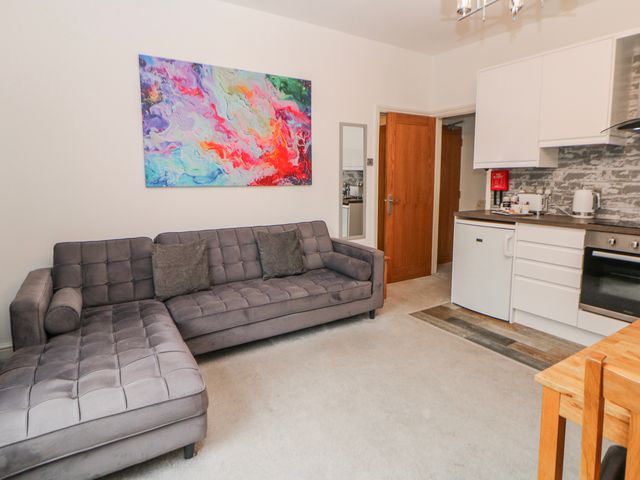 A living room with a sofa and kitchen at Abraham in Matlock