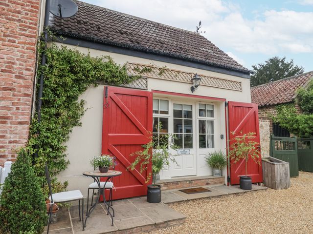 An outdoor area with red doors and a seating arrangement at The Farmhouse Kitchen in Ripon