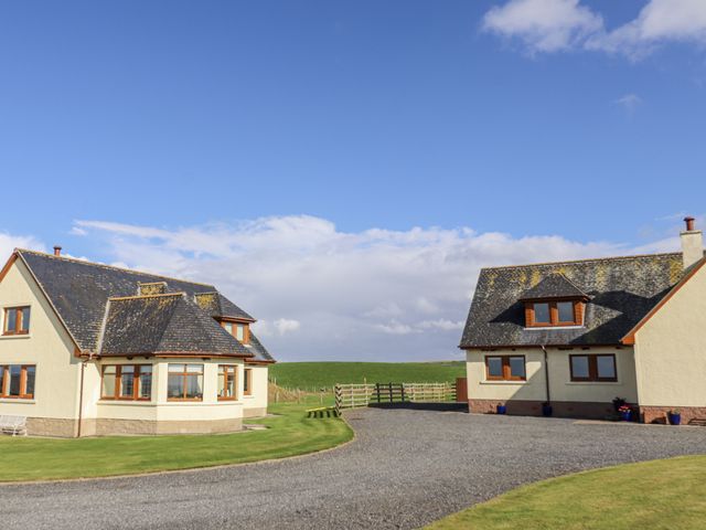 Two houses with a driveway and grass area at Corsewall Castle Farm Lodges Kirkcolm