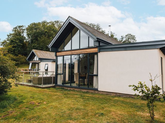 A house with a balcony and glass doors at Cowslip in Bamburgh