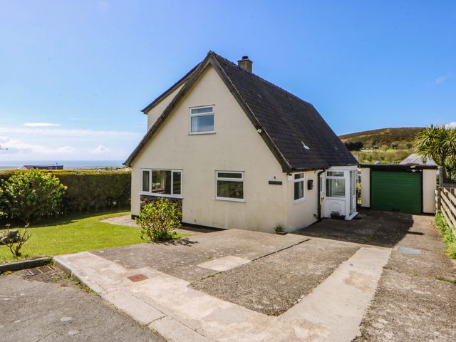 A house with a garden and driveway at Pen Y Garth in Mynytho near Llanbedrog