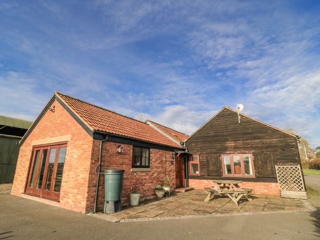 An exterior view of a cottage with patio and garden table at Keepers Cottage in West Knoyle
