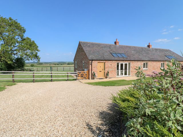 A house with a gravel driveway and green fields at Mandarin Cottage in Melton Mowbray
