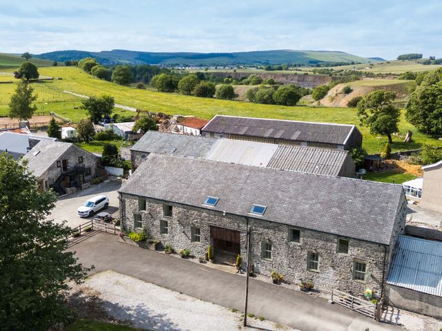 A landscape view of a stone building and fields at The Nest in Cowdale near Buxton