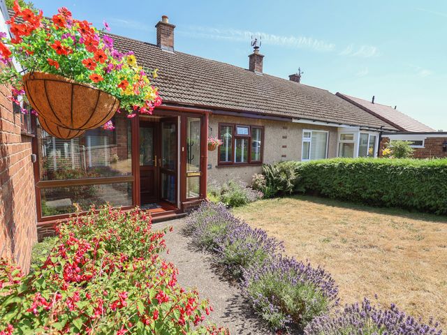 A garden with flowers and a door at Hillcrest in Cefn Mawr near Chirk