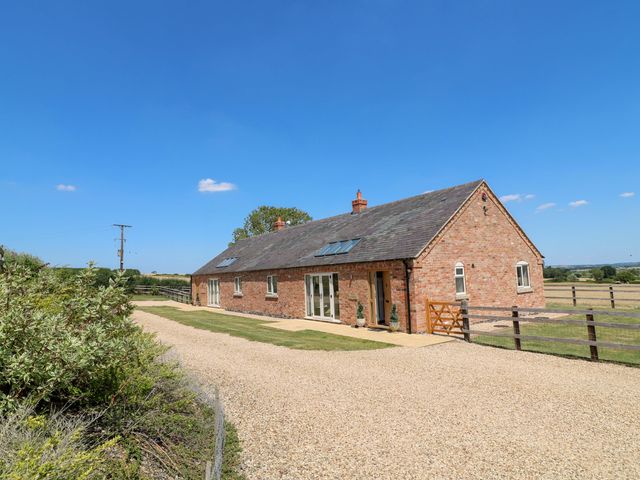 A house with a gravel driveway and garden at Teal Cottage in Melton Mowbray