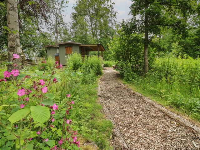 A path leading to a shed surrounded by flowers and trees at Bracken Fern in Eppleby