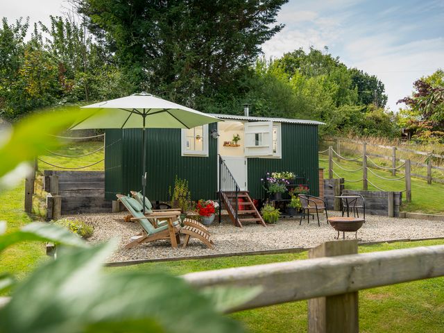 An outdoor area with a shepherd's hut and seating at Onnen Oakford near Aberaeron