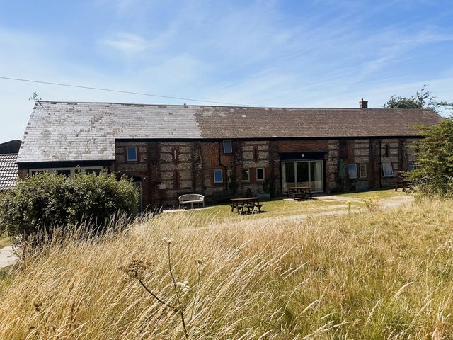 A building with tables and chairs in an outdoor area at Newfield Farm Cottages in Pimperne near Blandford Forum