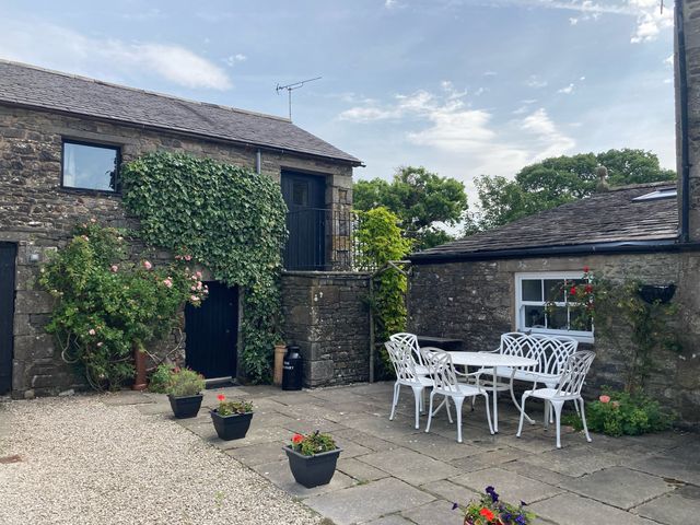 An outdoor seating area with a table and chairs at The Granary in Mansergh near Kirkby Lonsdale