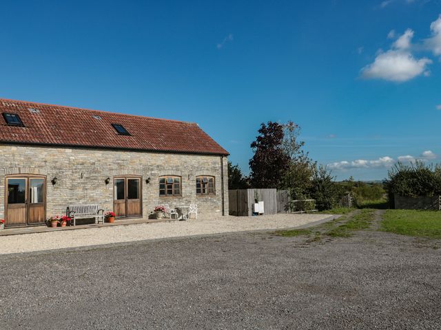 An outdoor area with a stone building and seating at Bramble Cottage Somerton