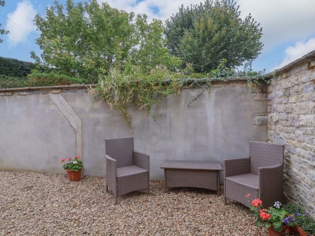 A garden with two chairs and a table at Badger Cottage Lydford-On-Fosse