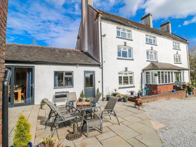 An outdoor patio with a table and chairs at Fields Farm in Cheadle